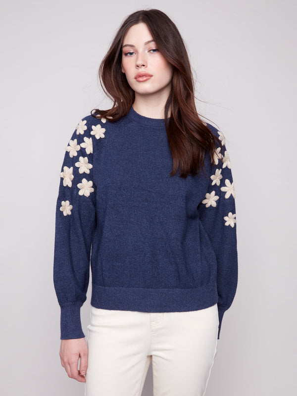 Denim sweater featuring intricate white floral embroidery on the shoulders, complemented by raglan puff sleeves for a stylish look by Charlie B.