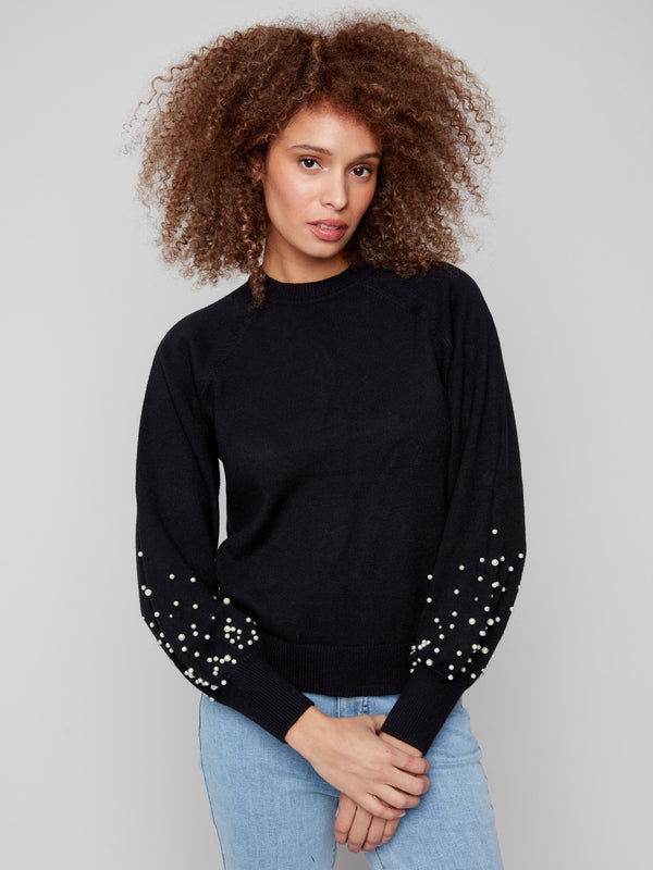 Chic black sweater adorned with stunning pearl details on its statement puff sleeves for a fashionable look by Charlie B.