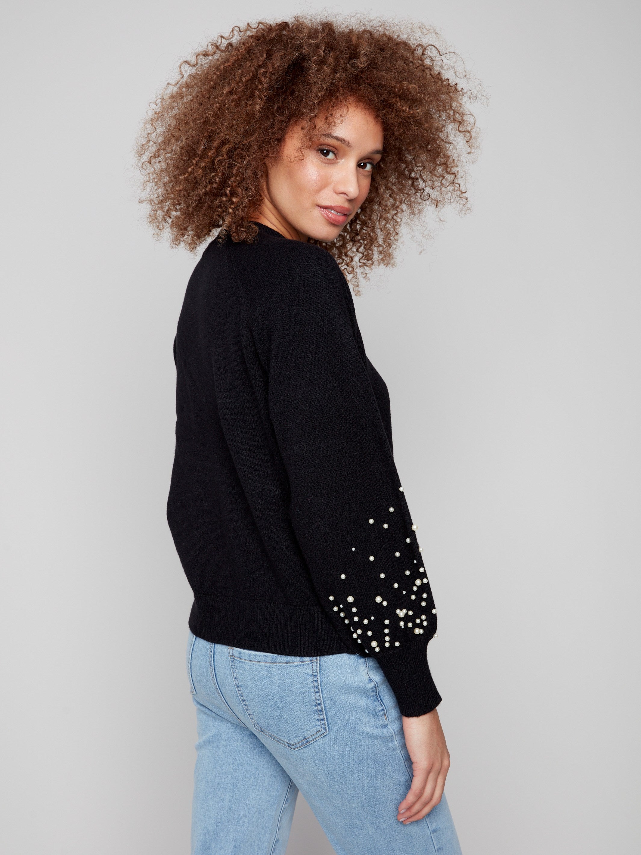 Sophisticated black knitwear showcasing intricate pearl designs on the sleeves, perfect for any occasion by Charlie B.
