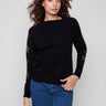 Elegant black sweater with star embellishments, highlighting the crew neck design for versatile styling by Charlie B.