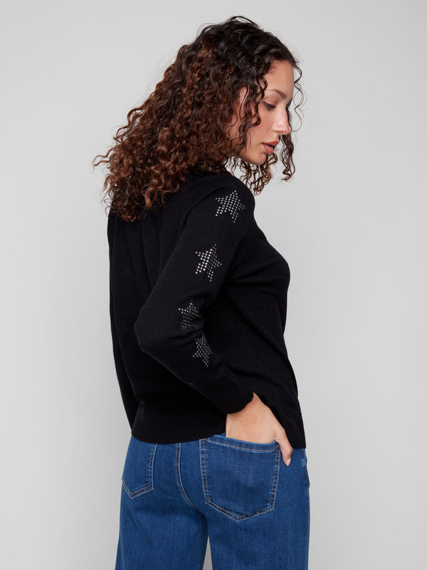 Sophisticated black sweater adorned with shimmering star studs, complemented by raglan sleeve structure by Charlie B.
