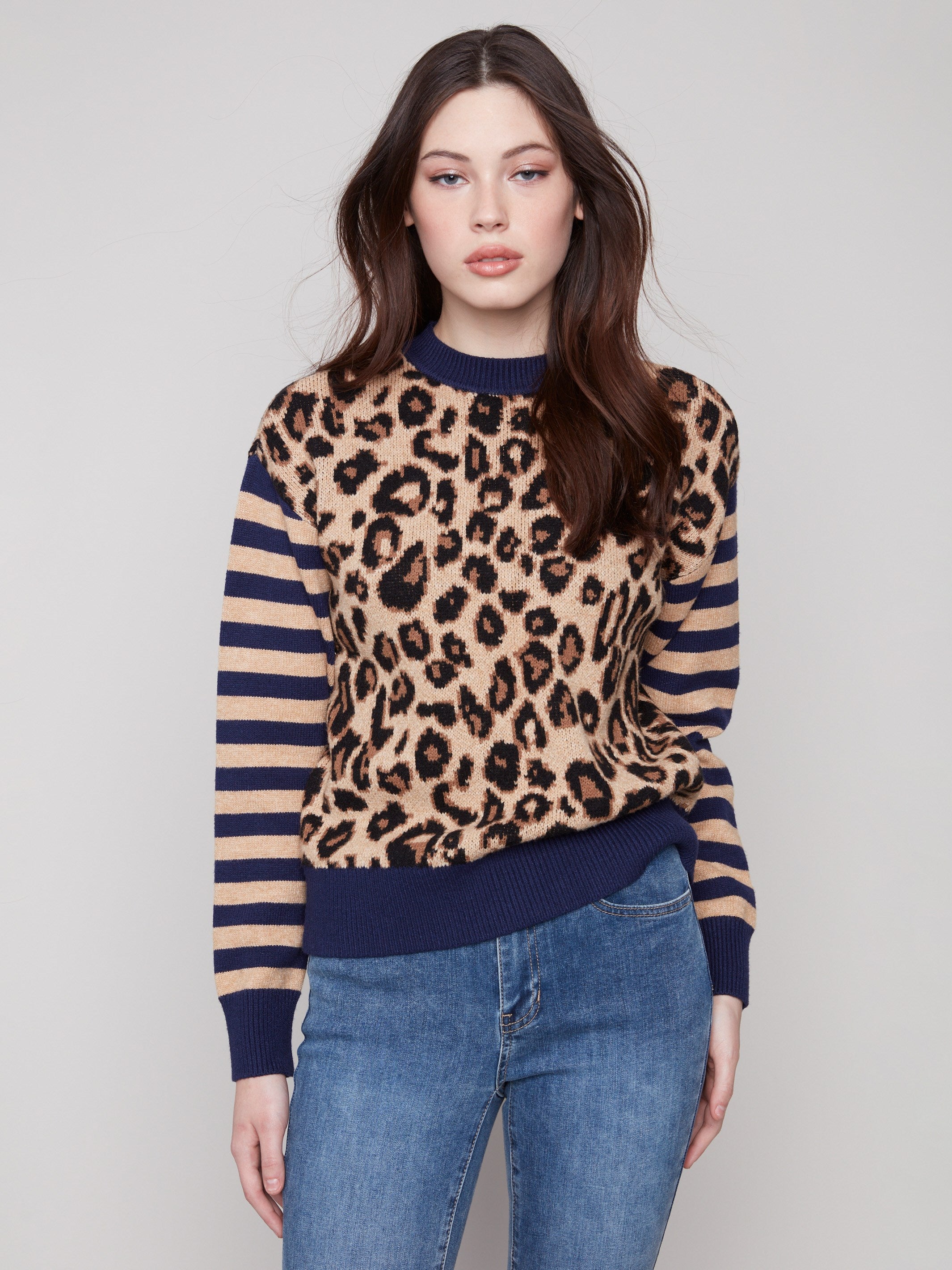Sweater featuring drop shoulders with a bold leopard print and striped sleeves by Charlie B.