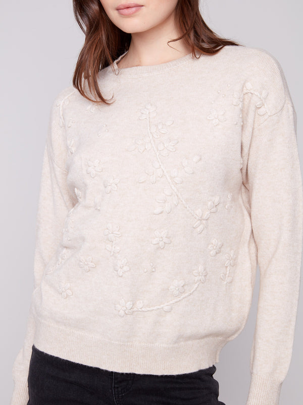 Tonal floral embroidery enhances the elegance of this heather oat sweater, making it a timeless piece by Charlie B.