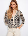 Intricate crochet top with a V-neck design, crafted in a delicate pattern with 3/4 sleeves for elegant style by Charlie B.