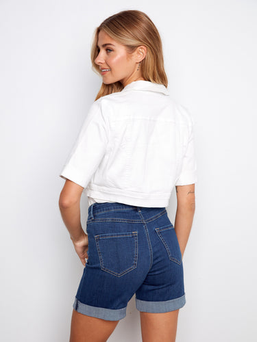 Elegant white jacket showcasing front chest pockets, perfectly matched with denim shorts for a casual vibe by Charlie B.