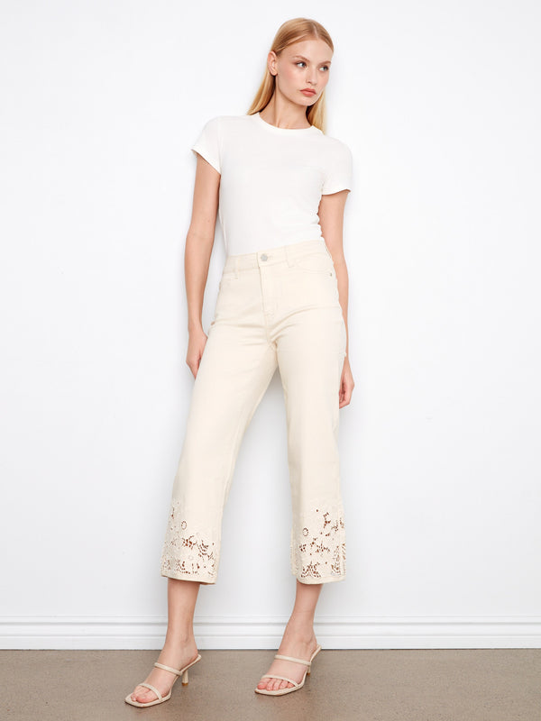 Cropped flare jeans in white with a flattering fit and beautiful laser-cut floral accents at the hem by Charlie B.