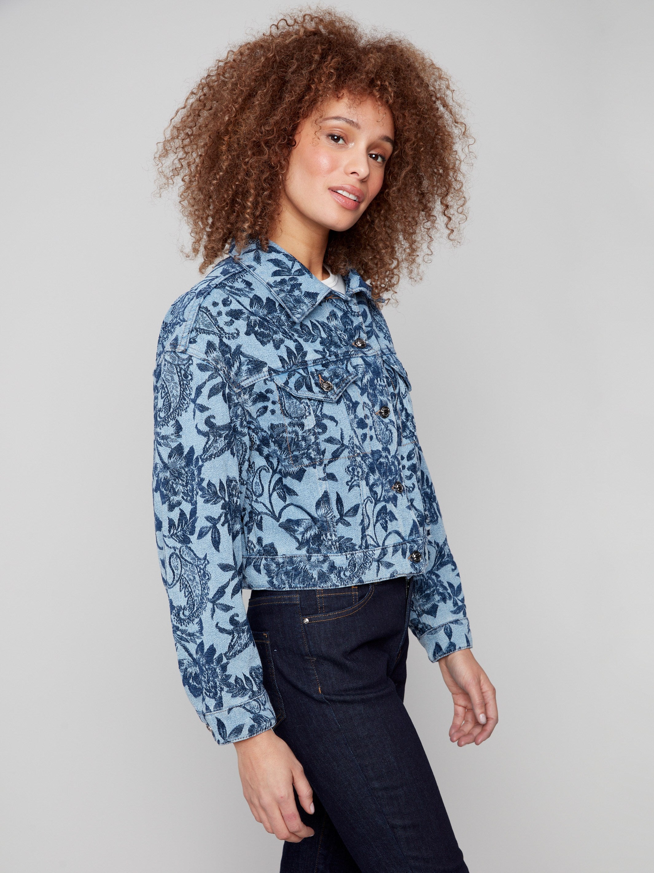 A button-front closure adds a classic touch to this blue denim jacket with floral detailing by Charlie B.