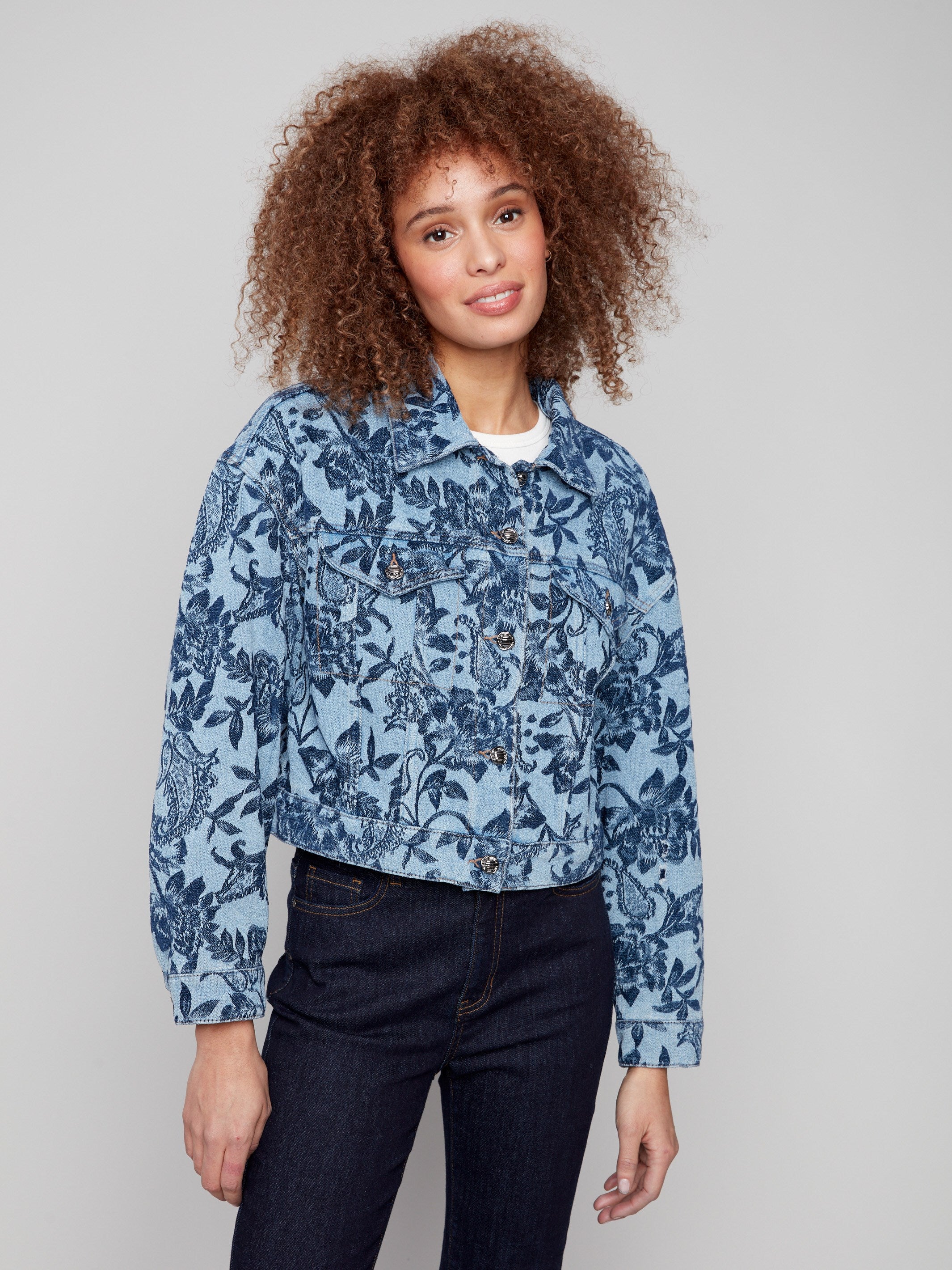 The intricate floral jacquard pattern elevates this blue cropped denim jacket for a chic look by Charlie B.