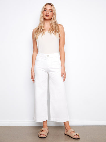 White cropped flare twill pants with chic design elements like patch pockets, modeled gracefully by Charlie B.