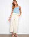 Natural twill pants in a straight fit, paired with a light blue top and sandals by Charlie B.