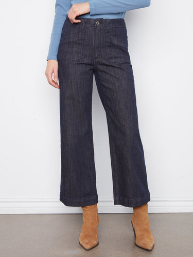 Showcasing cropped length denim pants with rectangular patch pockets, styled with a blue top. Perfectly finished by Charlie B.
