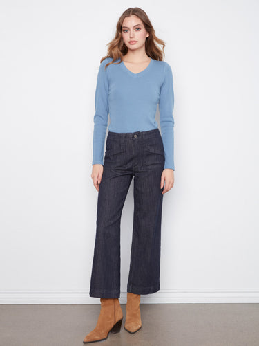 Cropped length stretch denim trousers paired elegantly with a blue long-sleeve top. A chic creation by Charlie B.