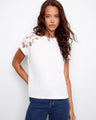 White cotton top featuring a crew neckline for a classic look. Enhanced with embroidery at the shoulder by Charlie B.