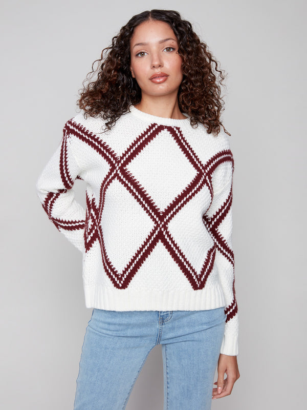 White sweater with cabernet diamond pattern and a cozy crew neck, highlighting the drop shoulder design by Charlie B.