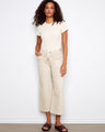 Beige wide-leg pants featuring a cropped length and drawstring waist, paired with casual sandals by Charlie B.