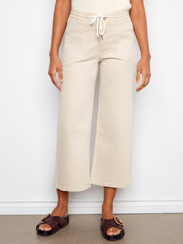 Stylish beige twill pants with patch pockets and a relaxed fit, complemented by open-toe sandals by Charlie B.