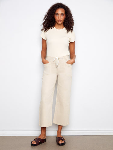 Chic beige pants with regular rise and wide-leg silhouette, perfect for versatile styling by Charlie B.