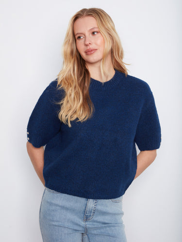 Elbow-length sleeve sweater in a relaxed fit, showcasing soft brushed knit and charming floral buttons on the cuffs by Charlie B.