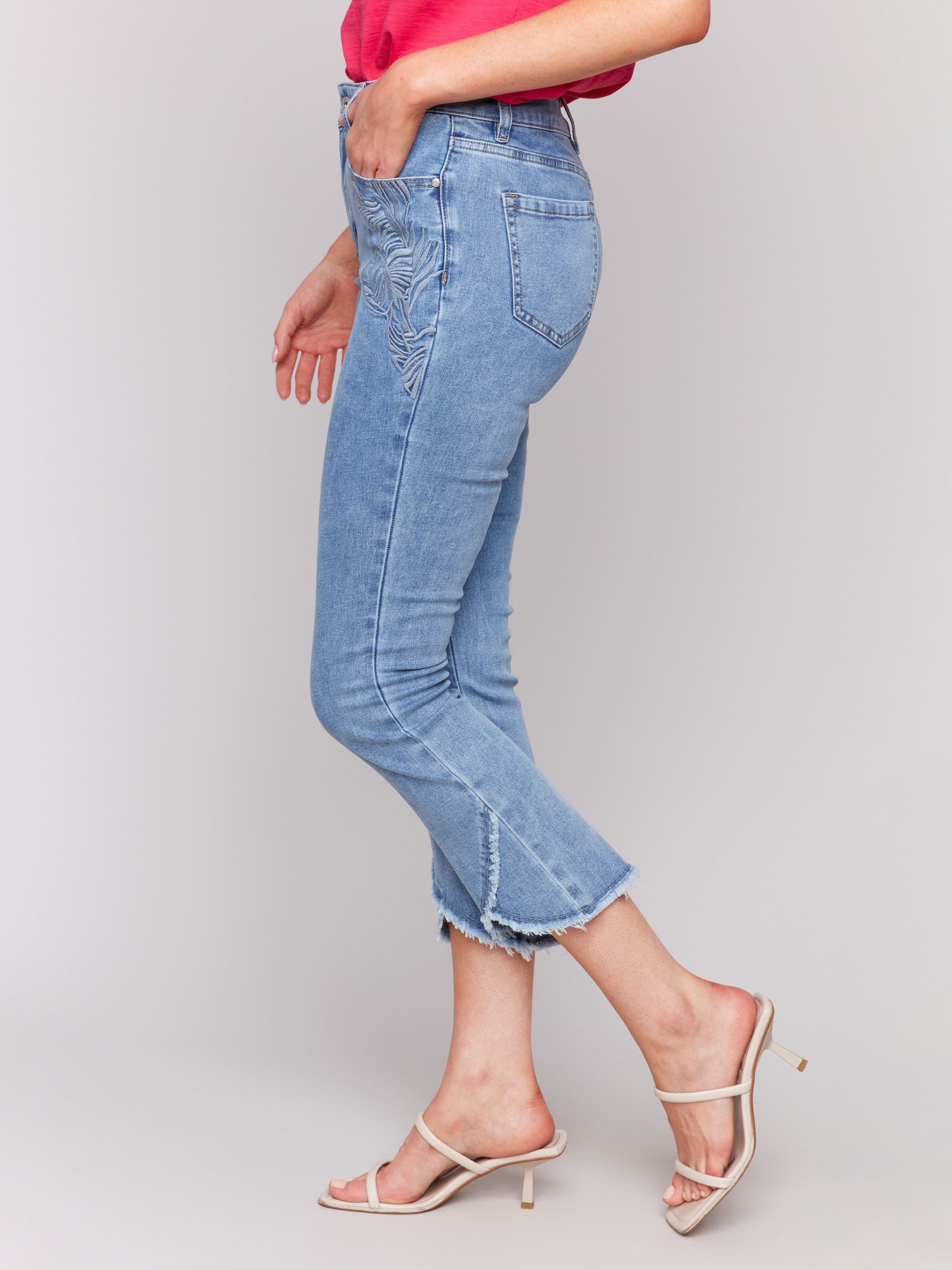 Regular rise bootcut jeans featuring frayed tulip hem by Charlie B.