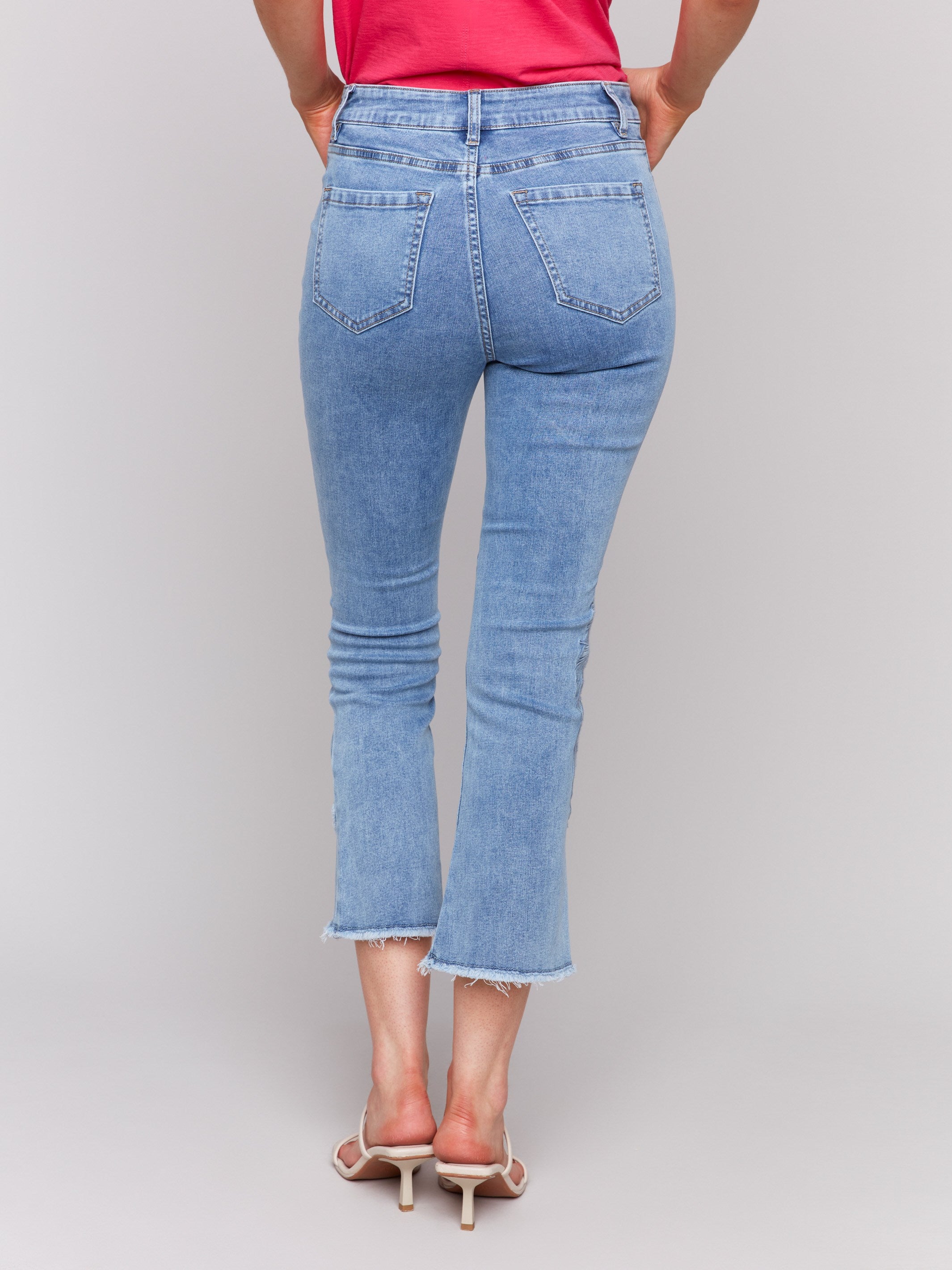 Embroidered light blue jeans with unique frayed edges by Charlie B.