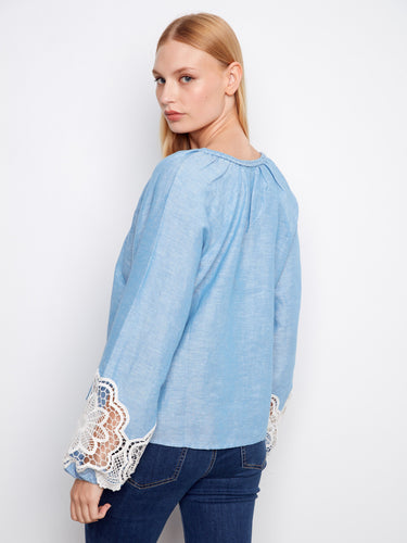 Elegant top featuring decorative buttons and charming openwork lace accents on the sleeves for added flair. By Charlie B.