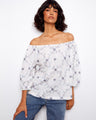 Elegant top with an off-the-shoulder design, showcasing intricate floral embroidery. Crafted from 100% cotton for comfort by Charlie B.