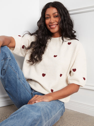Chic sweater adorned with embroidered hearts, combining comfort and style effortlessly. By Charlie B.