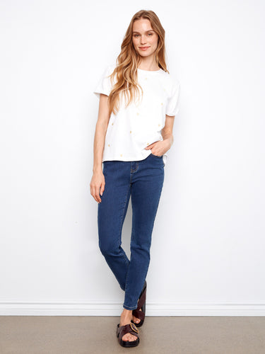 This white T-shirt showcases rolled cuffs, adding a casual yet stylish element to the design by Charlie B.