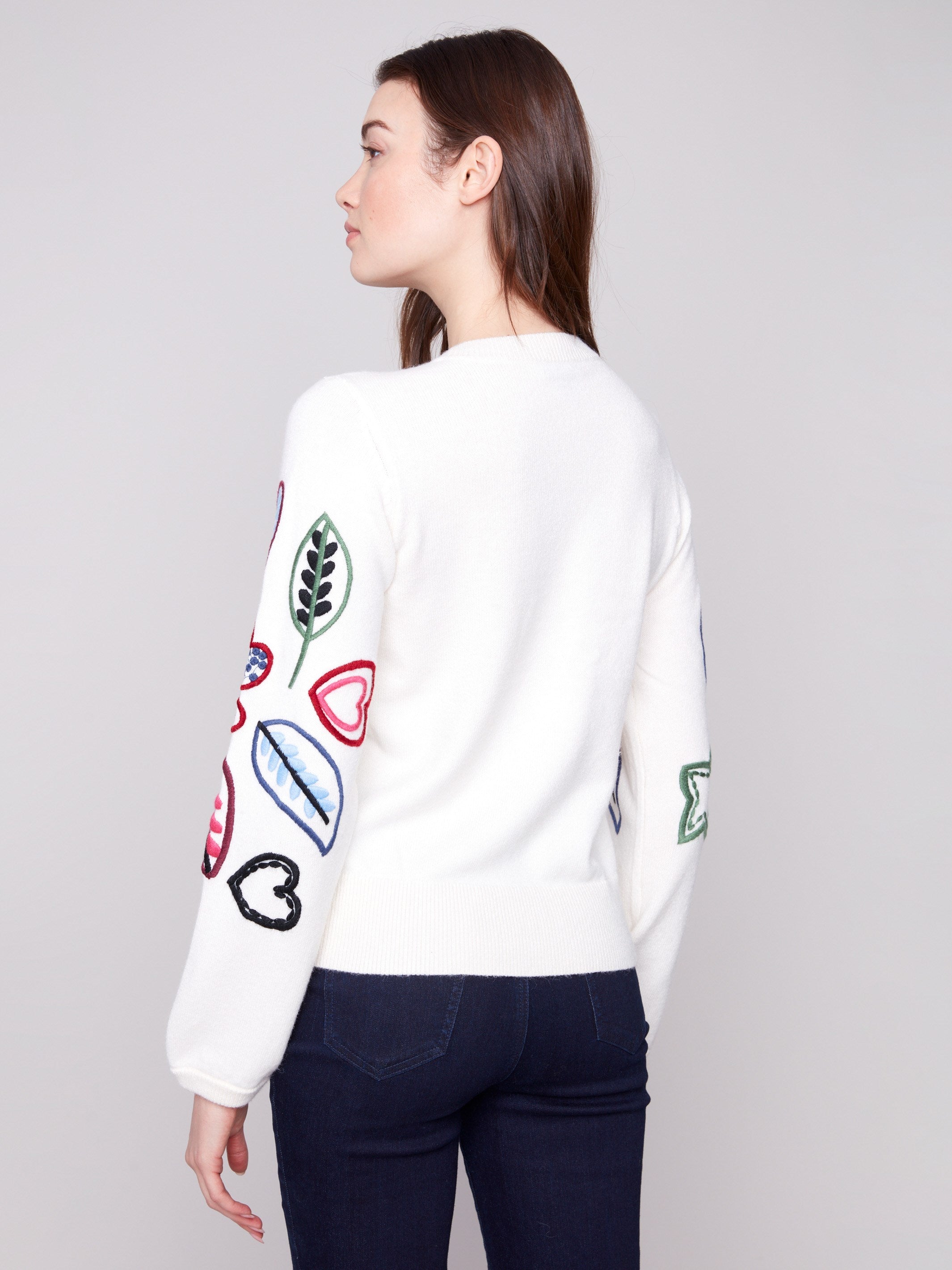Ecru sweater decorated with multicolored heart and leaf patterns, offering a comfortable relaxed fit by Charlie B.