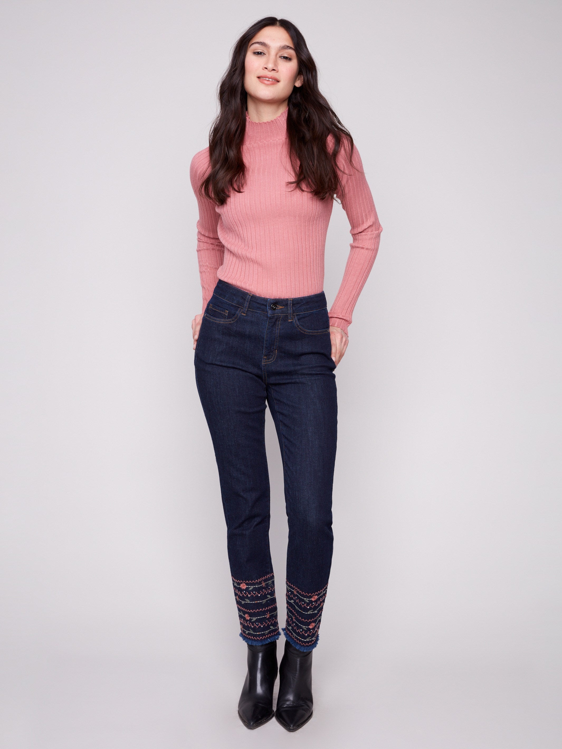 Embroidered hem detail enhances these stretch denim jeans, offering a sleek slim leg silhouette by Charlie B.