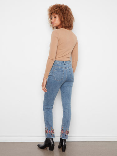 Slim fit denim in medium blue showcases an elegant embroidered hem, offering both style and comfort by Charlie B.