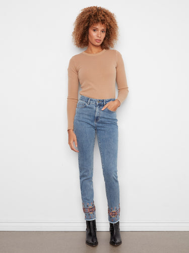 Slim fit medium blue jeans featuring an elegant embroidered hem and classic five-pocket design by Charlie B.
