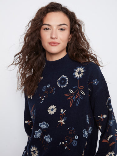 Elegant navy sweater adorned with intricate floral embroidery and long sleeves, offering a chic mock neck style by Charlie B.