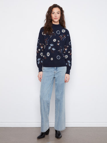 Charming navy sweater showcasing floral embroidery, complete with a cozy mock neck and drop shoulder design by Charlie B.