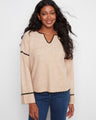 Beige sweater with a notch neck and ribbed knit texture, perfect for casual outings. By Charlie B.