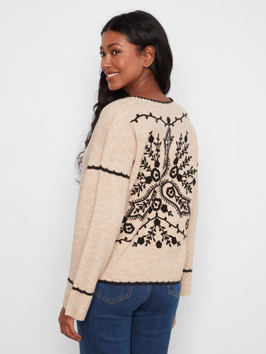 Showcasing an elegant embroidered back design, this beige sweater adds a unique touch. By Charlie B.