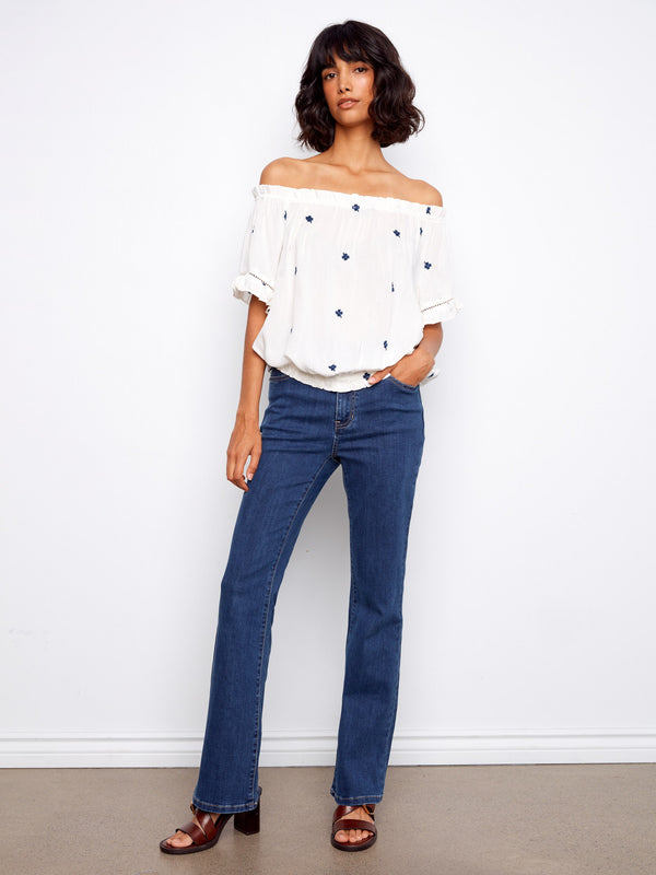 Elegant off-shoulder top adorned with blue floral embroidery and a stylish elastic hem by Charlie B.