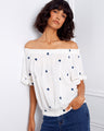 Stylish white blouse featuring short flutter sleeves and intricate blue embroidery for a casual look by Charlie B.