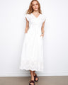 White V-neck dress featuring an empire elastic waist and hidden pockets by Charlie B.