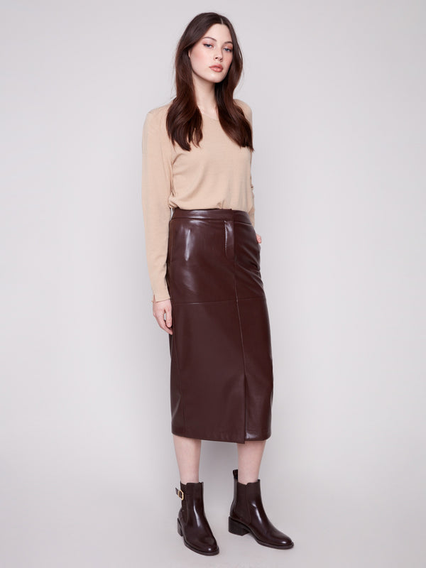 Cabernet faux leather midi skirt featuring side pockets, paired with a beige top and brown ankle boots by Charlie B.