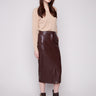 Cabernet faux leather midi skirt featuring side pockets, paired with a beige top and brown ankle boots by Charlie B.
