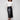 Black faux leather midi skirt with convenient side pockets, paired elegantly with a white top and black ankle boots by Charlie B.