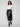 Chic black faux leather midi skirt featuring a stylish slit front hem, complemented by a white top and ankle boots by Charlie B.