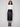 Trendy black faux leather midi skirt showcasing its elegant midi length, matched perfectly with a white top and ankle boots by Charlie B.