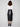 Fashionable black faux leather midi skirt designed with front fly closure, paired seamlessly with a white top and chic ankle boots by Charlie B.