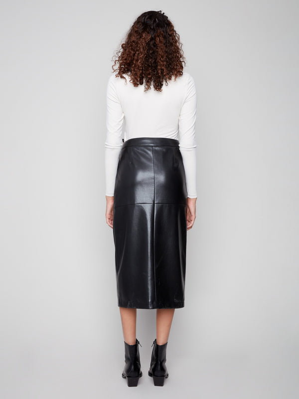 Fashionable black faux leather midi skirt designed with front fly closure, paired seamlessly with a white top and chic ankle boots by Charlie B.