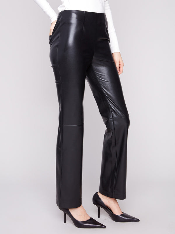 Featuring an elegant seam above the knee, these black faux leather pants offer a modern look by Charlie B.