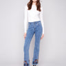 Blue jeans featuring a stylish flare leg with colorful floral embroidery, crafted in stretch denim for comfort by Charlie B.