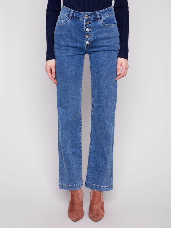 Five-pocket design in medium blue denim paired with a dark top for style and function by Charlie B.