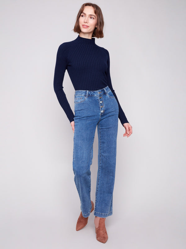 Stylish medium blue jeans paired with a dark top, offering both stretch and comfort in denim by Charlie B.
